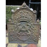 A cast iron fire back of stepped arched form with armorial shield, crown and foliate detail, 60 cm