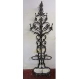 A good quality cast iron hall stand, the raised back with scrolling foliate detail, over a coiled