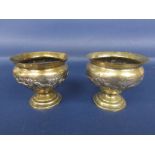 Pair of eastern white metal pedestal dishes, each embossed with a band of wild animals, 8oz approx