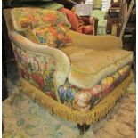 A Howard style low deep seated lounge chair with shaped arms, beige ground and partial tapestry