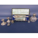A mixed collection of silverware to include a pair of dwarf candlesticks, silver lidded cut glass