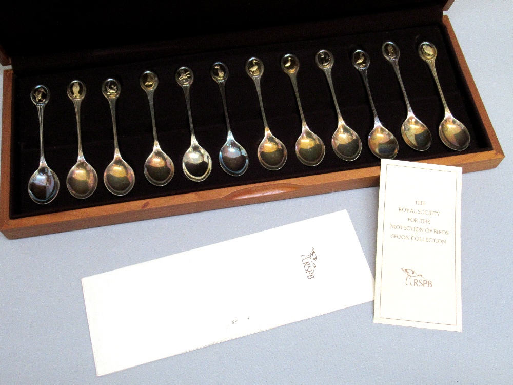 THE RSPB SILVER SPOON COLLECTION COMPRISING 12 SILVER SPOONS, EACH FINIAL WITH A GILT OVAL PANEL