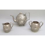 LATE C19th INDIAN SILVER THREE PIECE TEASET COMPRISING A SPERICAL TEAPOT WITH ALL OVER CHASED AND