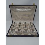 SET OF 12 CONTINENTAL SILVER DISHES SURMOUNTED BY CHERUBS, STAMPED 800, CASED, H: 5.8cm, W: 7cm (
