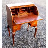 FIGURED WALNUT KNEEHOLE BUREAU WITH A CYLINDER TOP DISCLOSING A FITTED INTERIOR, SLIDE AND FOUR