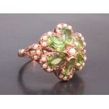 9ct GOLD FLORAL RING SET 6 x 6mm OVAL PERIDOT AND 25 SEED PEARLS SET IN CLUSTERS OF THREE WITH A