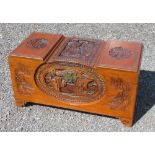 ORIENTAL CAMPHOR LINED CHEST WITH A HINGED DOMED TOP AND CARVED FIGURE, FLORAL, BUILDING AND BOAT