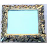 A 19TH CENTURY BAROQUE REVIVAL STYLE ITALIAN GILTWOOD CARVED MIRROR FRAME WITH SCROLLED FOLIATE