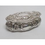 AN EDWARDIAN SILVER REPOUSSE BOX, THE HINGED COVER AND FRONT WITH VACANT SCROLL CARTOUCHES, ON A