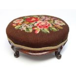 A VICTORIAN MAHOGANY CARVED OVAL FOOTSTOOL ON FOUR CABRIOLE LEGS UPHOLSTERED IN TAPESTRY (H. 17