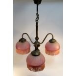 A FRENCH ANTIQUE FINISH THREE BRANCH ELECTROLIER (DROP 52 CM) WITH THREE PINK FROSTED GLASS SHADES