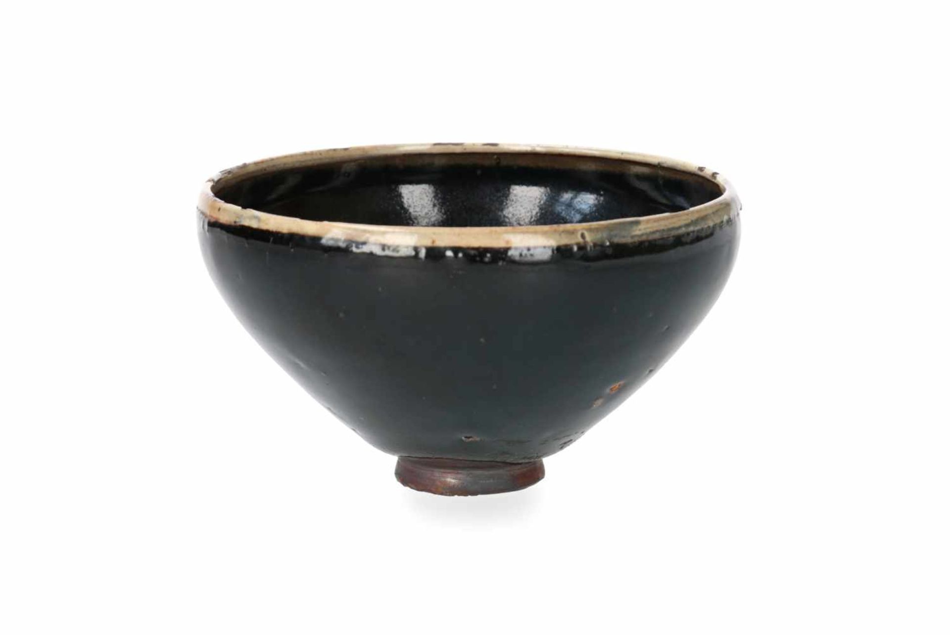 A black glazed bowl with cream glazed rim. China, Honan, Song. H. 7,5 cm. Diam. 14 cm.