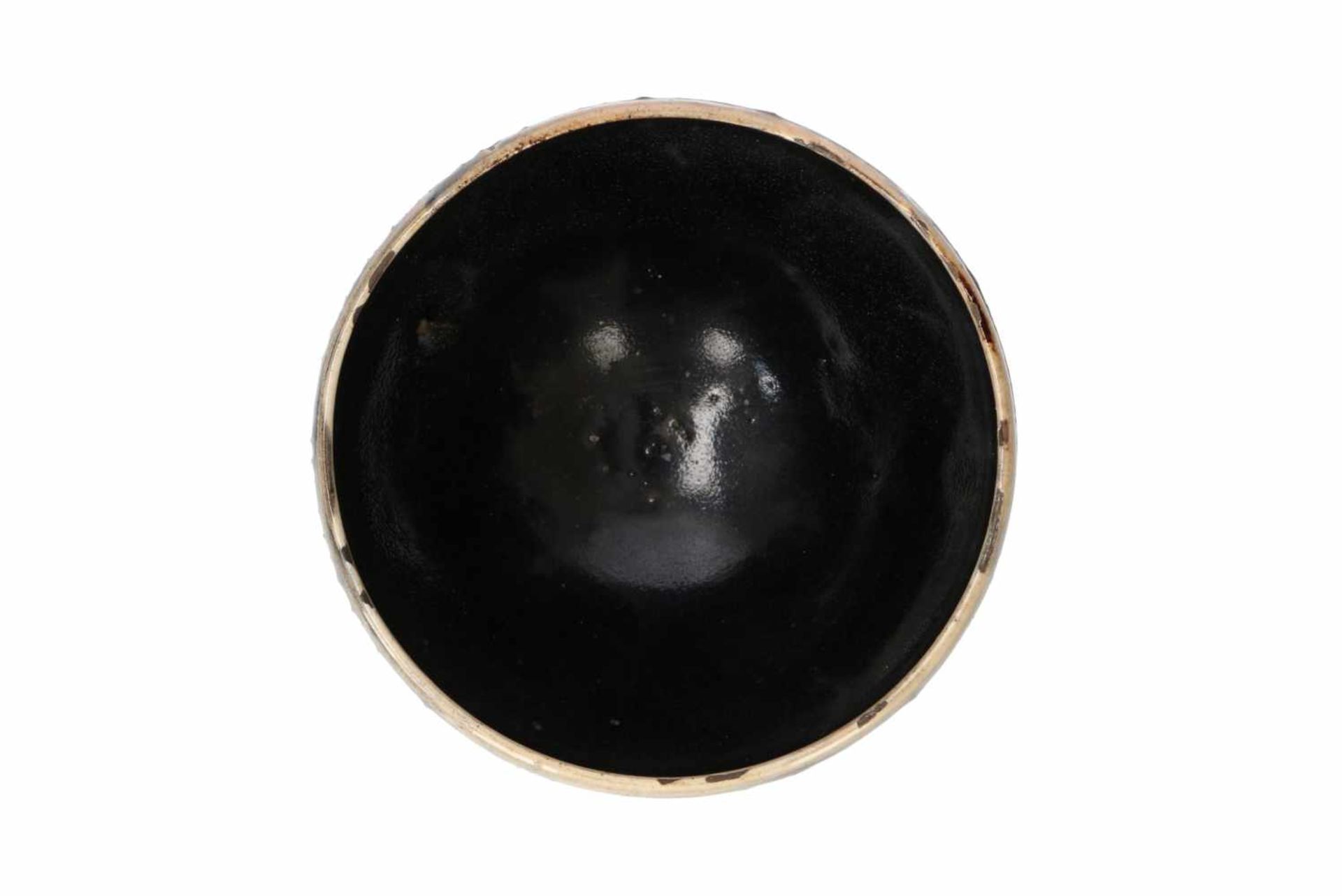 A black glazed bowl with cream glazed rim. China, Honan, Song. H. 7,5 cm. Diam. 14 cm. - Image 4 of 5