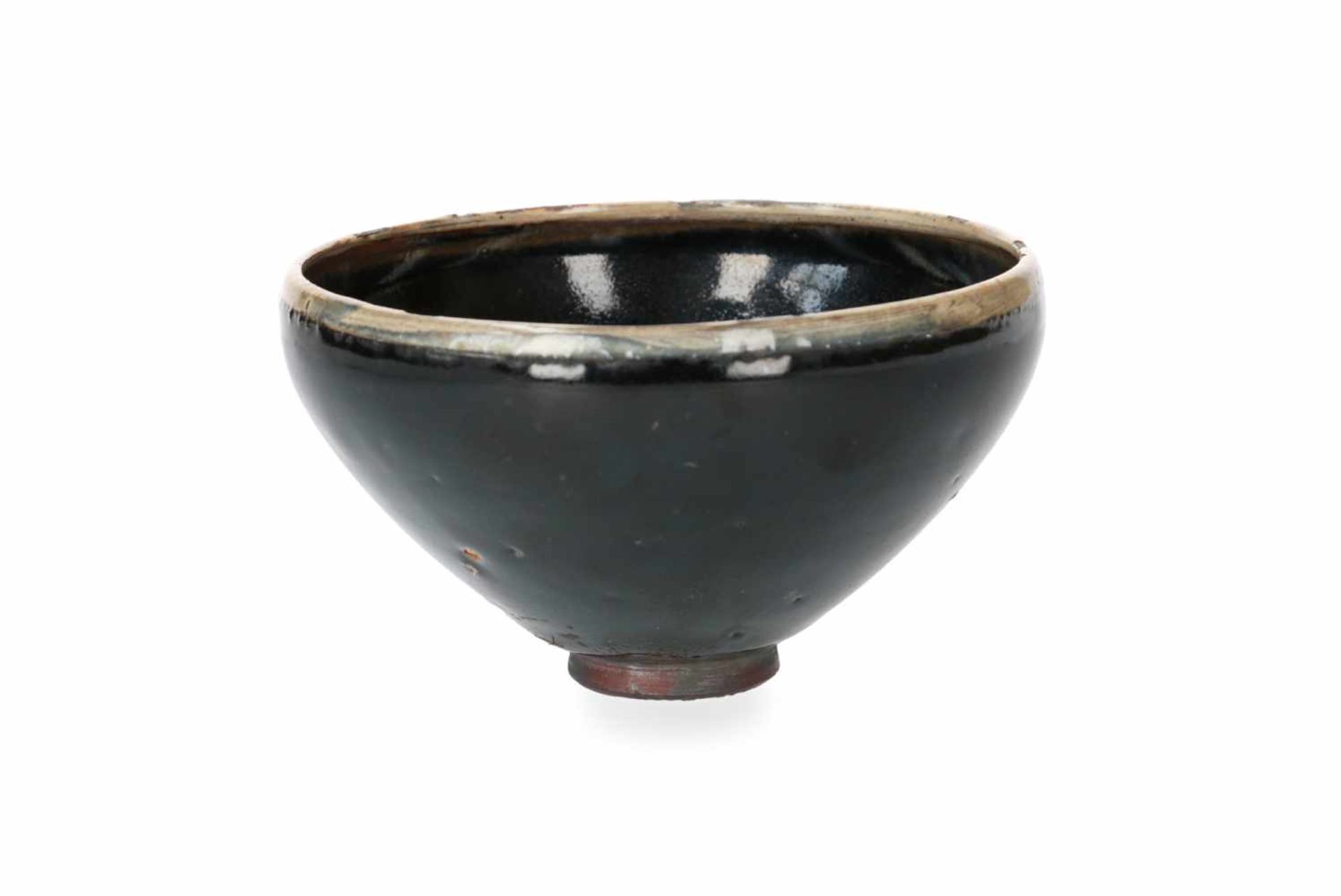 A black glazed bowl with cream glazed rim. China, Honan, Song. H. 7,5 cm. Diam. 14 cm. - Image 2 of 5