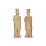 A pair of pottery court dignitaries with long wide sleeves and traces of celadon green glaze. China,