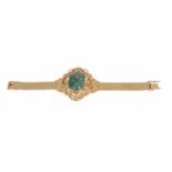 18-kt gouden schakelarmband met vast middenstuk, bezet met groene steen. L. 15,5 cm. tot. gew. ca.