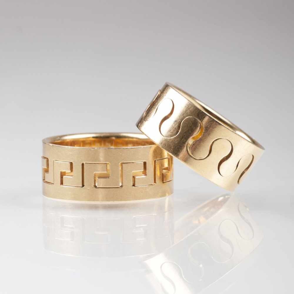 Zwei Gold-Bandringe 18 kt. GG, gest. Umlaufend Durchbruch-Bandornamentik. Herren-Ring: B. 9 mm,