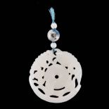 A CHINESE WHITE JADE ‘BAT AND FISH’ PENDANT the circular pendant centred by a pi disc supported by