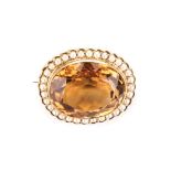 A CITRINE AND PEARL BROOCH the 42.42cts oval mixed-cut Madeira type citrine surrounded by 32 2.3mm