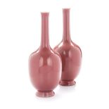 A PAIR OF CHINESE COPPER-RED ‘STICK-NECK’ VASES each ovoid body rising to a tall slender neck with a