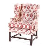 A GEORGE III WINGBACK UPHOLSTERED ARMCHAIR the padded back and sides above a loose seat cushion,