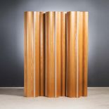 A MOULDED PLYWOOD FOLDING SCREEN DESIGNED BY RAY AND CHARLES EAMES of wave like design joined by