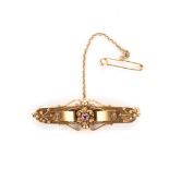 A 15K YELLOW GOLD BROOCH the memorial brooch centred with a pink tourmaline, with a safety chain and