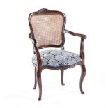 A CAPE REGENCY STINKWOOD ARMCHAIR the carved back within a conforming frame surmounted by a floral