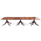 A REGENCY MAHOGANY EXTENDING DINING TABLE the rounded rectangular top on three pedestal supports,