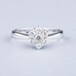 AN 18K WHITE GOLD AND DIAMOND CLUSTER RING the six diamonds, approximately I/J, clarity SI and 0.