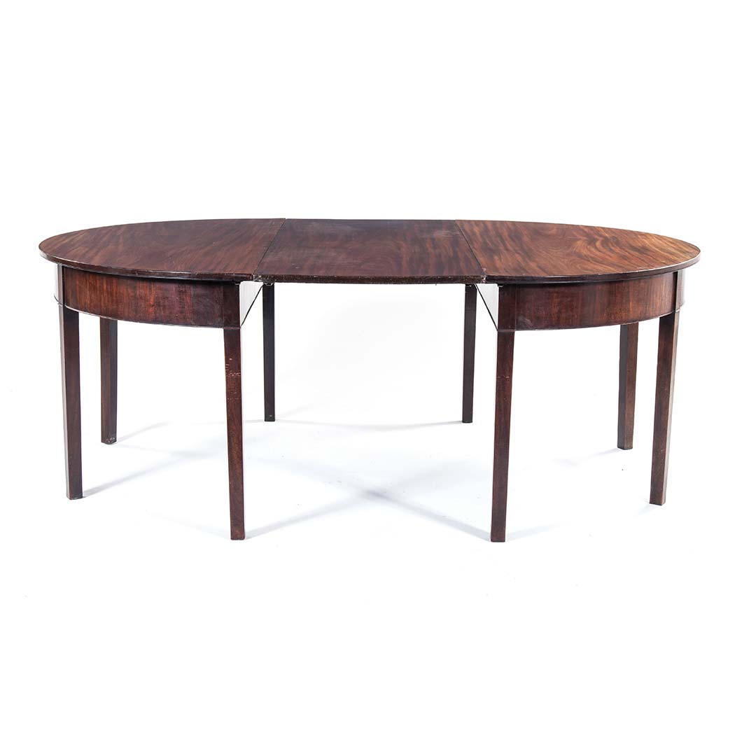 A GEORGE III MAHOGANY EXTENDING DINING TABLE