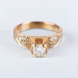 A GOLD AND DIAMOND RING the central diamond, colour I, clarity SI3 is claw set and flanked by a