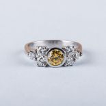 A PLATINUM DIAMOND RING the centre fancy yellow diamond, approximately 0.57ct is flanked by six