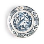 A CHINESE BLUE AND WHITE PLATE the well painted with a phoenix amongst flora and fauna, contained