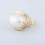 A MABE PEARL AND DIAMOND RING the oval mabe pearl is tube set with diamonds set at the shoulders