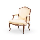 A WALNUT AND UPHOLSTERED ARMCHAIR, 19TH CENTURY the curved top rail above a padded back, padded