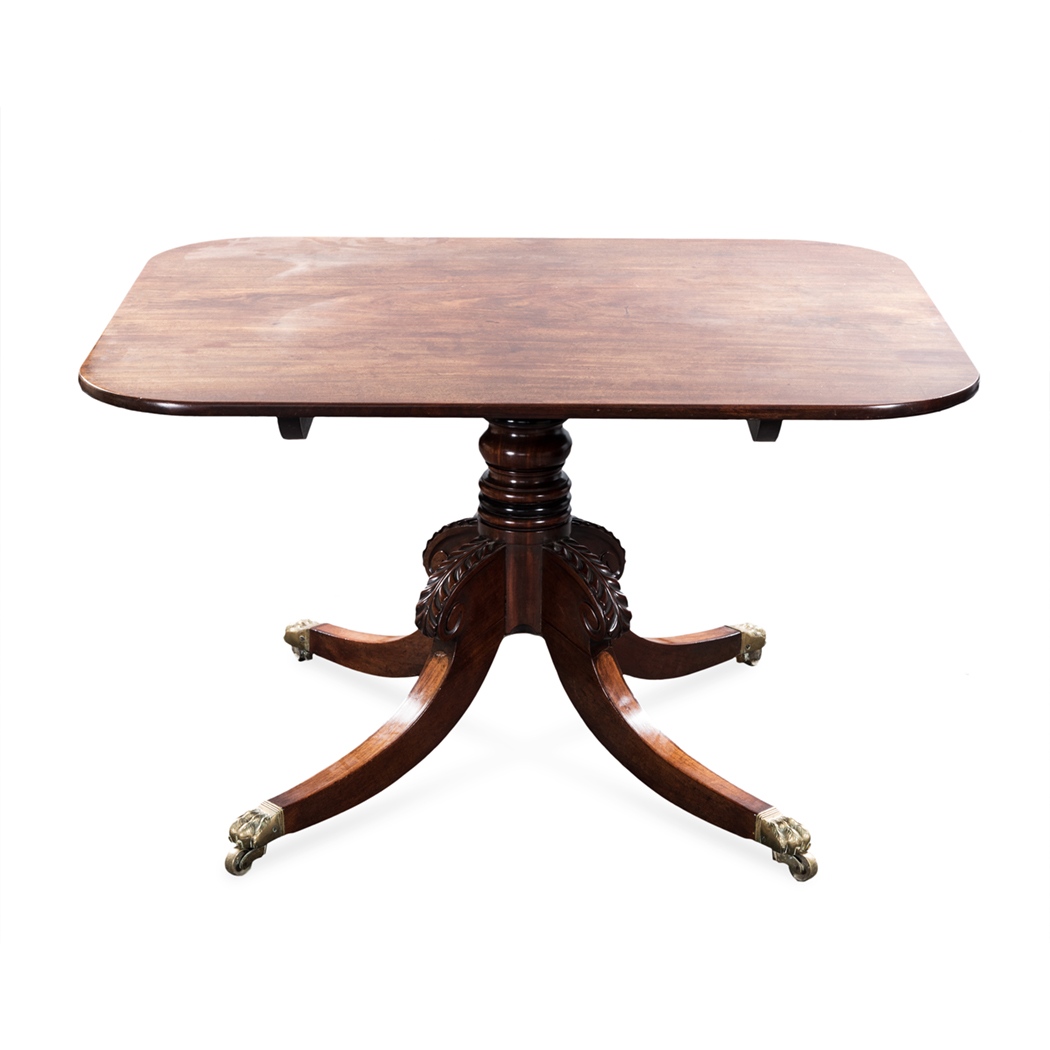 A REGENCY MAHOGANY BREAKFAST TABLE the rounded rectangular top on a ring-turned support, drum