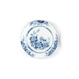 A CHINESE BLUE AND WHITE CHARGER the central rondel depicting blossoms and peonies beside a table