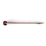 A 9K YELLOW GOLD AND GARNET BAR BROOCH the round garnet is tube set to the and or a gold bar brooch