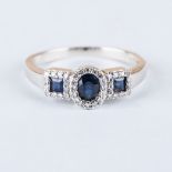 A SAPPHIRE AND DIAMOND RING the central oval sapphire is surrounded by round brilliant cut