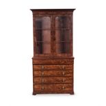 A GEORGE III WALNUT VENEERED BOOKCASE-ON-CHEST in two parts, the rectangular outswept cornice
