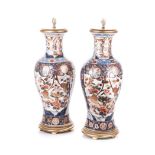 A PAIR OF LARGE PORCELAIN LAMPS each tapering ovoid with flared rim, covered overall in flowers,