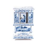 A DUTCH DELFT MINIATURE FOOD CUPBOARD of rectangular shape, with a hinged door, supported on