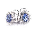 A PAIR OF TANZANITE AND DIAMOND EARRINGS each centred with an oval mixed-cut tanzanite weighing