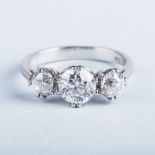 A PLATINUM AND DIAMOND TRILOGY RING the central diamond weighing approximately 1ct, colour H/I,