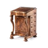 A VICTORIAN WALNUT DAVENPORT the hinged serpentine-shaped top with a gilt-tooled leather inset