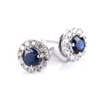 A PAIR OF SAPPHIRE AND DIAMOND EARRINGS each centred with a circular mixed cut sapphire, the