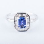 AN 18K WHITE GOLD, DIAMOND AND TANZANITE RING the emerald cut tanzanite is claw set and surrounded