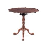 A MAHOGANY PIE-CRUST TILT-TOP TRIPOD TABLE the shaped circular top on a birds nest support, carved