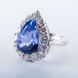 A PLATINUM, TANZANITE AND DIAMOND RING, PLATANDIA the 7.331ct pear cut tanzanite is surrounded by 15